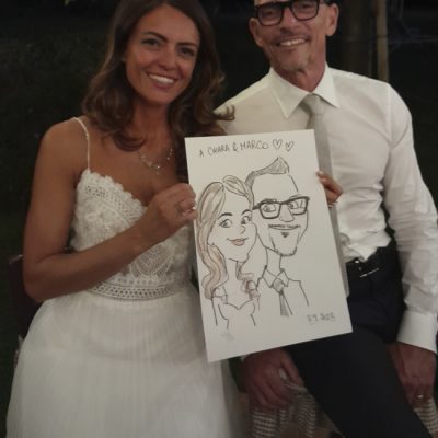 una coppia di sposi mostra la caricatura appena ricevuta dal caricaturista